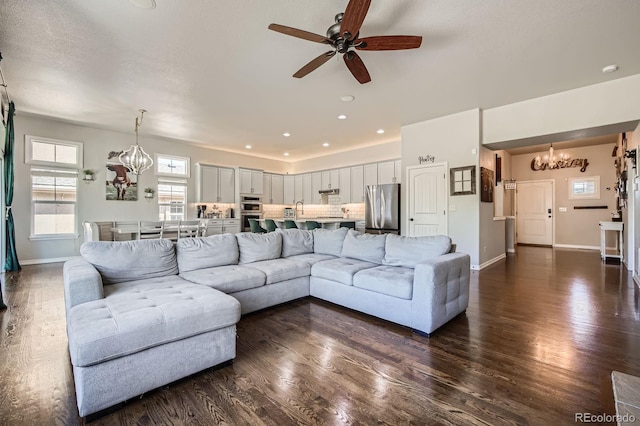 4866 Rainbow Gulch Trl, Colorado Springs, CO 80924 - living room with a chandelier, dark wood-style floors, ceiling fan, and baseboards