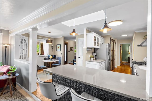 11224 W 28th Pl, Lakewood, CO 80215 - kitchen featuring light wood-style flooring, white cabinetry, glass insert cabinets, appliances with stainless steel finishes, and a breakfast bar area