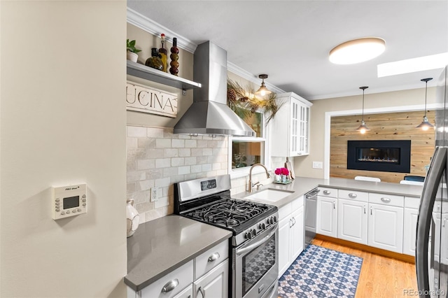 11224 W 28th Pl, Lakewood, CO 80215 - kitchen with stainless steel appliances, a sink, island range hood, white cabinets, and ornamental molding