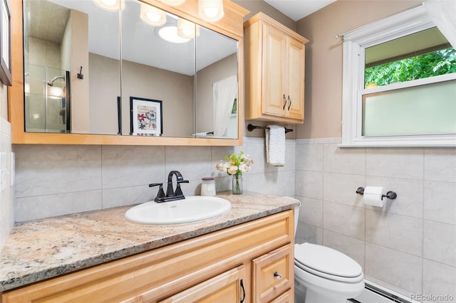 11224 W 28th Pl, Lakewood, CO 80215 - full bathroom featuring vanity, toilet, a baseboard radiator, tile walls, and a shower