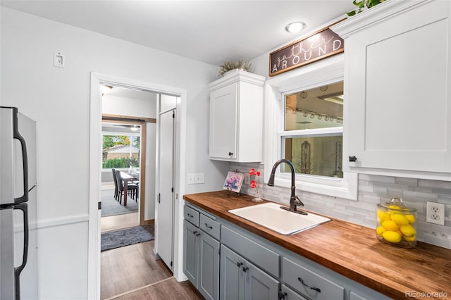 11224 W 28th Pl, Lakewood, CO 80215 - kitchen featuring a sink, wooden counters, freestanding refrigerator, and tasteful backsplash