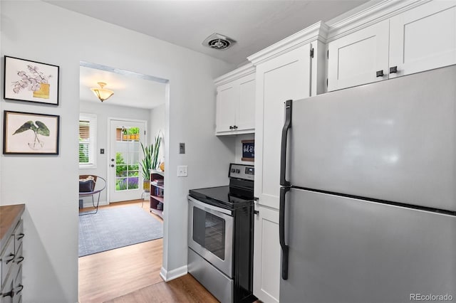 11224 W 28th Pl, Lakewood, CO 80215 - kitchen featuring stainless steel appliances, wood finished floors, white cabinetry, and baseboards