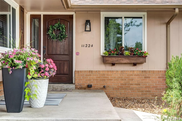 11224 W 28th Pl, Lakewood, CO 80215 - property entrance with roof with shingles, brick siding, and a porch