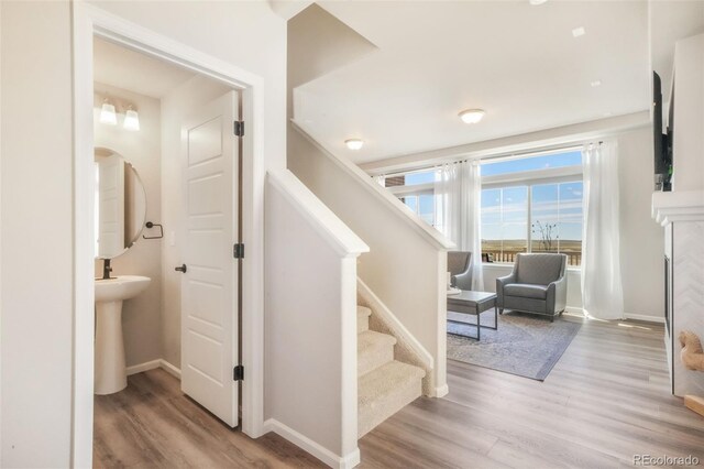 9521 Sideoats Ct, Colorado Springs, CO 80927 - staircase featuring wood finished floors, baseboards, arched walkways, and a fireplace