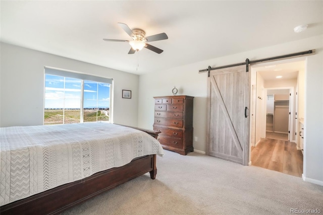 9521 Sideoats Ct, Colorado Springs, CO 80927 - carpeted bedroom with a barn door, a ceiling fan, and baseboards