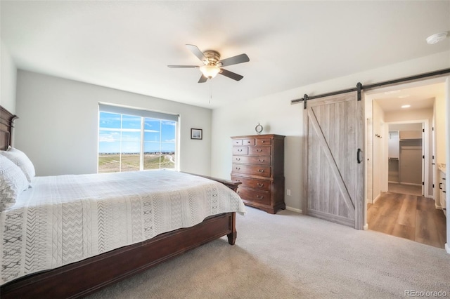 9521 Sideoats Ct, Colorado Springs, CO 80927 - carpeted bedroom with a barn door, a ceiling fan, and baseboards