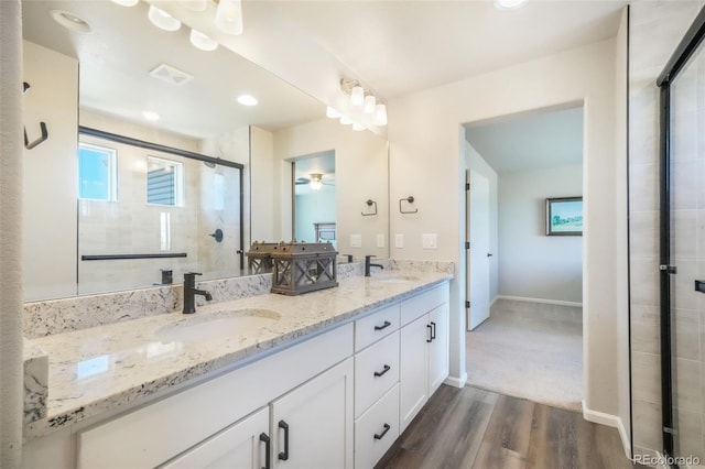 9521 Sideoats Ct, Colorado Springs, CO 80927 - bathroom with double vanity, a shower stall, wood finished floors, baseboards, and a ceiling fan