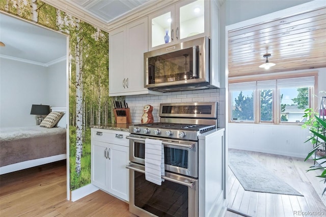 4716 Broadway, Denver, CO 80216 - kitchen featuring stainless steel appliances, crown molding, light wood-style flooring, white cabinets, and glass insert cabinets