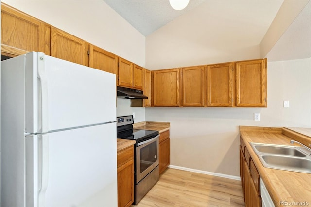 kitchen featuring a sink, electric range, light wood-type flooring, freestanding refrigerator, and under cabinet range hood