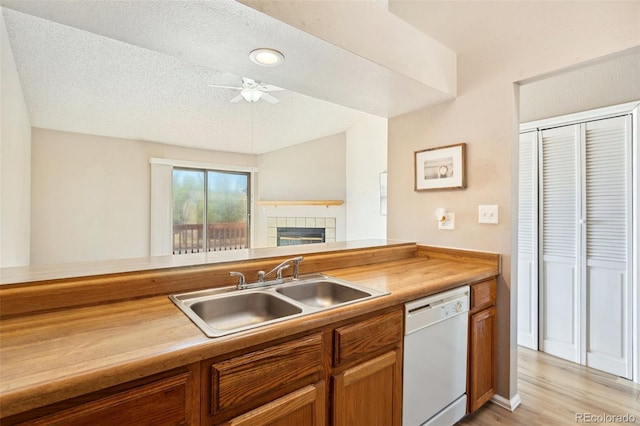 kitchen with dishwasher, a ceiling fan, brown cabinetry, and a sink