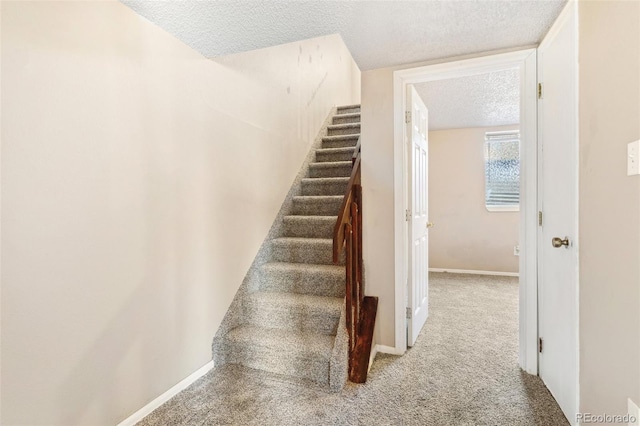 stairs with carpet floors, a textured ceiling, and baseboards