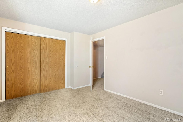unfurnished bedroom with baseboards, carpet, and a closet