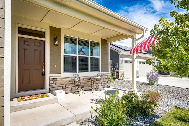 view of exterior entry with a garage and covered porch