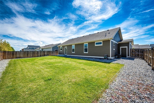 back of house featuring central AC unit and a lawn