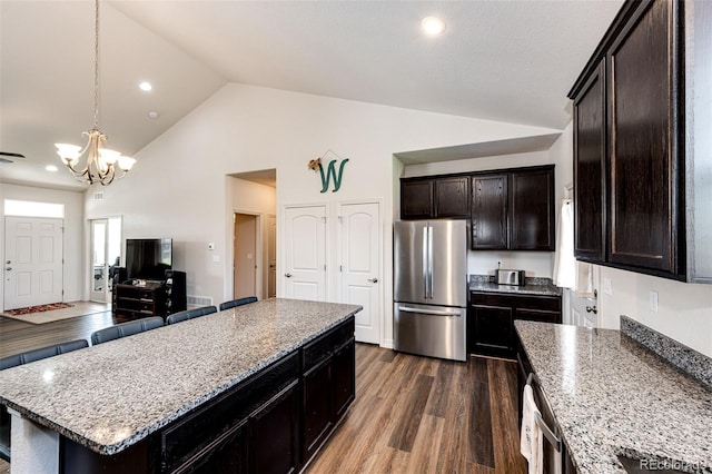 kitchen featuring decorative light fixtures, a center island, a notable chandelier, stainless steel appliances, and dark wood-type flooring