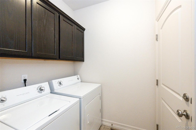 washroom featuring cabinets and washer and clothes dryer