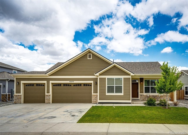 56459 E 23rd Pl, Strasburg, CO 80136 - view of front facade with stone siding, concrete driveway, a front yard, and an attached garage