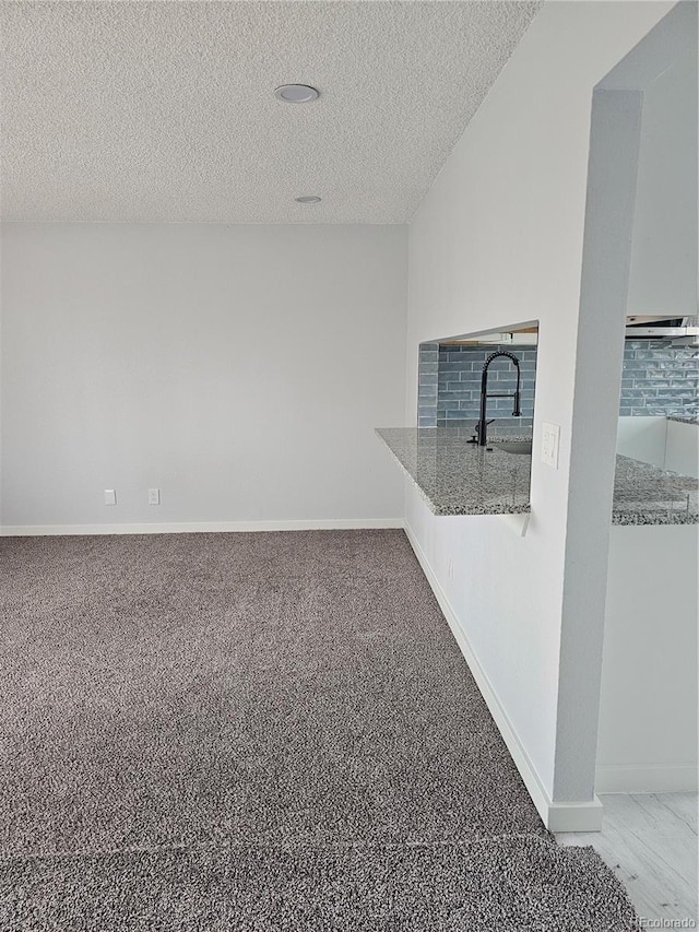 interior space with a textured ceiling and sink