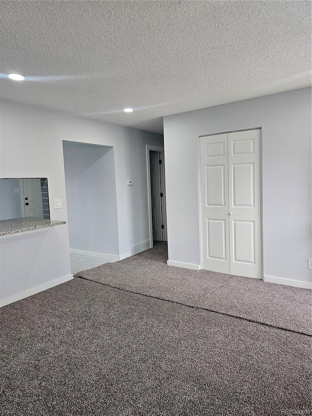 unfurnished room with carpet floors and a textured ceiling