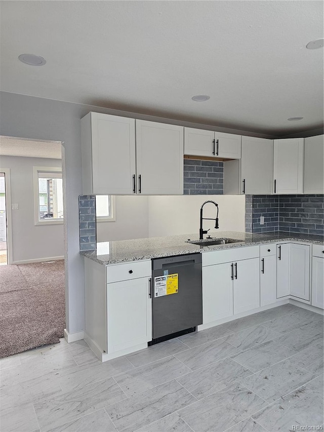 kitchen featuring white cabinetry, dishwasher, light carpet, and sink