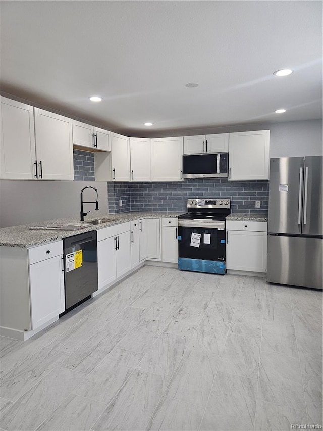 kitchen with white cabinets, light stone countertops, sink, and appliances with stainless steel finishes