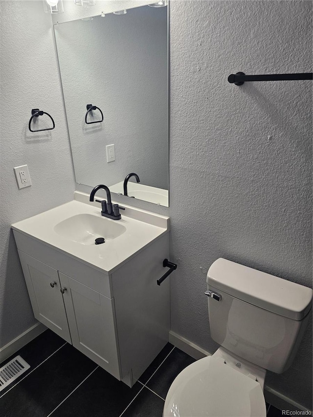 bathroom featuring toilet, vanity, and tile patterned floors