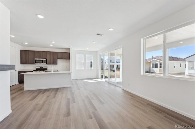 interior space with light wood-style floors, stainless steel appliances, open floor plan, and a sink