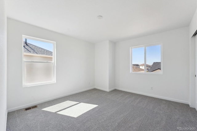 empty room with plenty of natural light and carpet floors