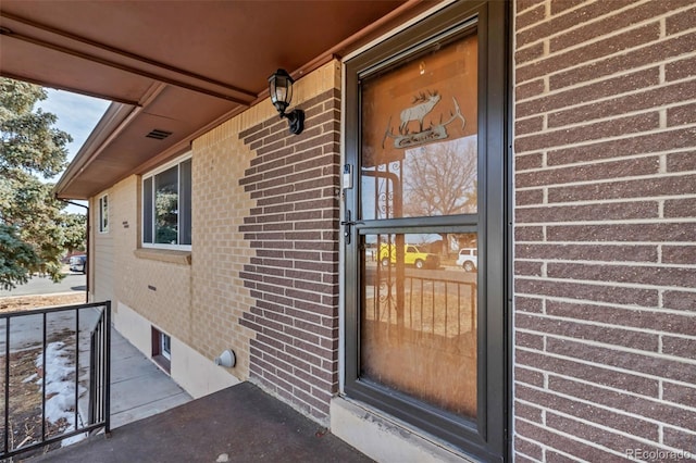 entrance to property featuring brick siding