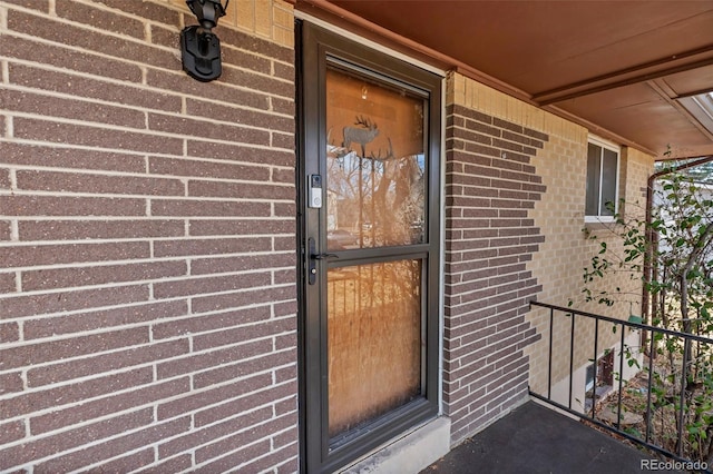 doorway to property with brick siding