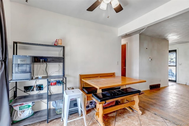 dining space with light wood-type flooring, ceiling fan, visible vents, and baseboards