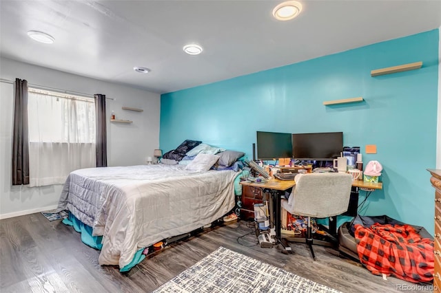 bedroom with baseboards, wood finished floors, and recessed lighting