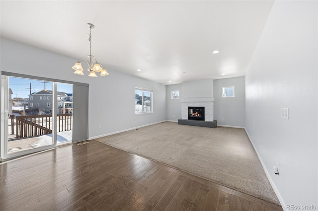 unfurnished living room featuring a chandelier and hardwood / wood-style flooring