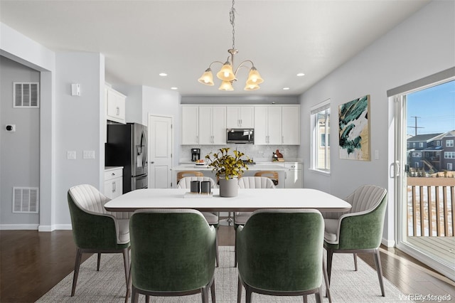 dining area with a notable chandelier and wood-type flooring