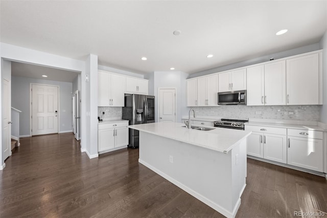 kitchen with white cabinets, a kitchen island with sink, stainless steel appliances, dark wood-type flooring, and sink