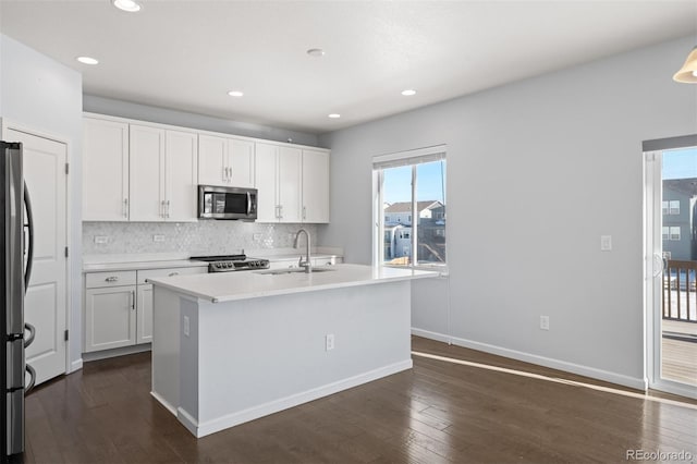 kitchen featuring stainless steel appliances, white cabinetry, and a kitchen island with sink