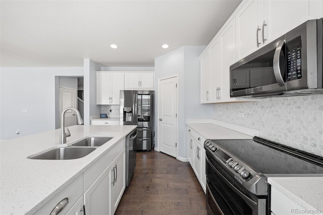 kitchen with stainless steel appliances, white cabinets, sink, and light stone countertops