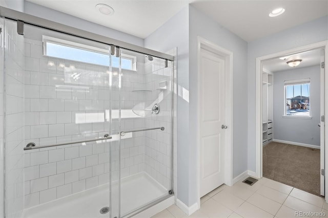 bathroom with a shower with door and tile patterned flooring