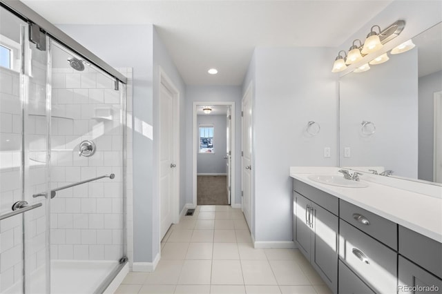 bathroom featuring tile patterned flooring, a shower with door, and vanity