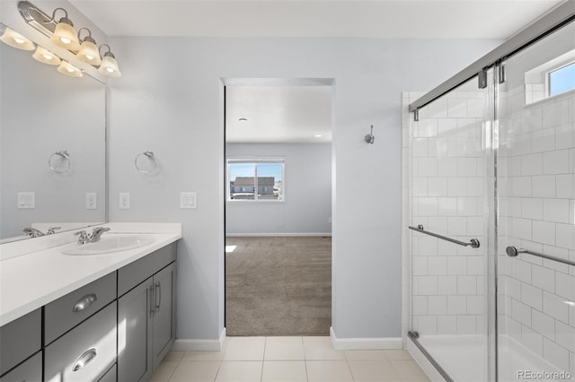 bathroom featuring vanity, tile patterned flooring, a healthy amount of sunlight, and walk in shower