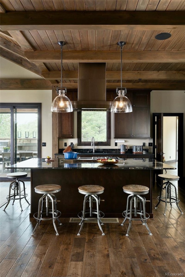 kitchen with pendant lighting, a wealth of natural light, and a kitchen bar