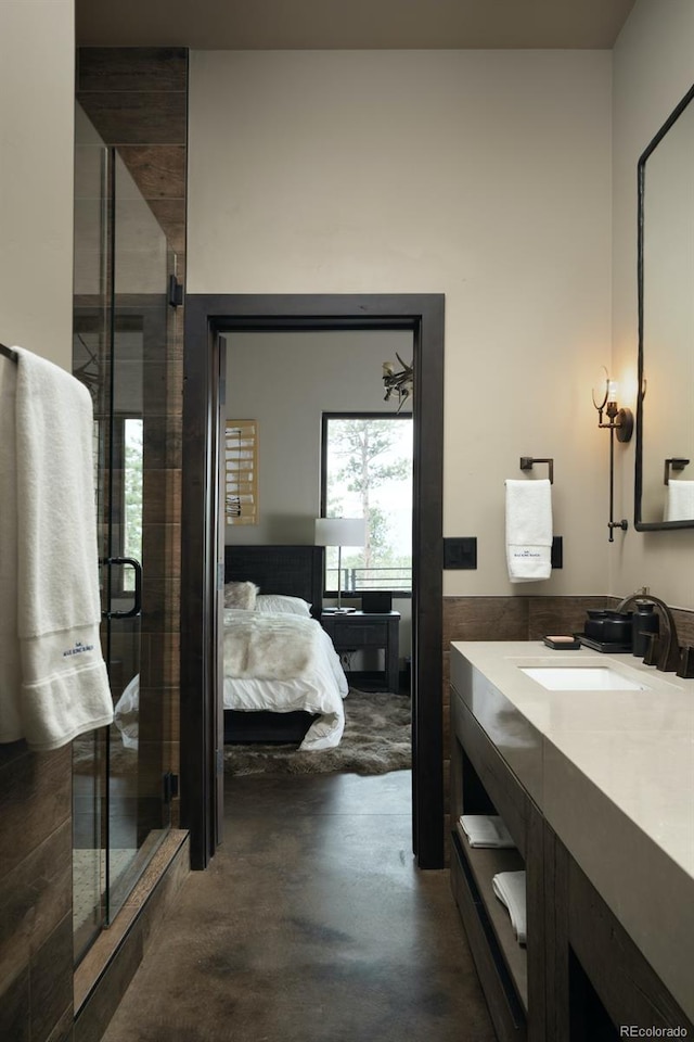 bathroom with vanity, concrete floors, and a shower with door