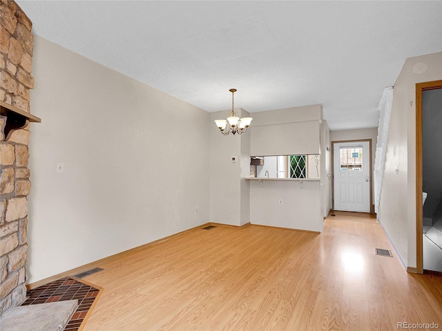 2627 E Nichols Cir, Centennial, CO 80122 - unfurnished living room featuring a chandelier, light wood finished floors, and baseboards
