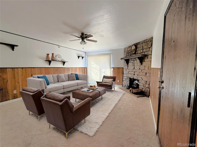 390 Zang St Unit 5-102, Lakewood, CO 80228 - carpeted living room featuring ceiling fan, a fireplace, wooden walls, and a textured ceiling
