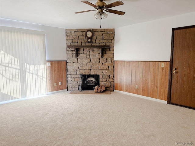390 Zang St Unit 5-102, Lakewood, CO 80228 - unfurnished living room with a stone fireplace, carpet flooring, ceiling fan, and wood walls