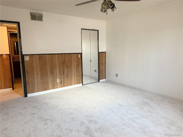390 Zang St Unit 5-102, Lakewood, CO 80228 - unfurnished bedroom featuring ceiling fan, light colored carpet, and wooden walls