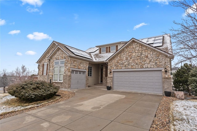 view of front facade with a garage, roof mounted solar panels, and concrete driveway