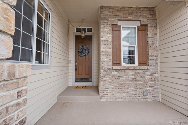 entrance to property featuring brick siding