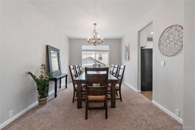 carpeted dining space with baseboards and a chandelier