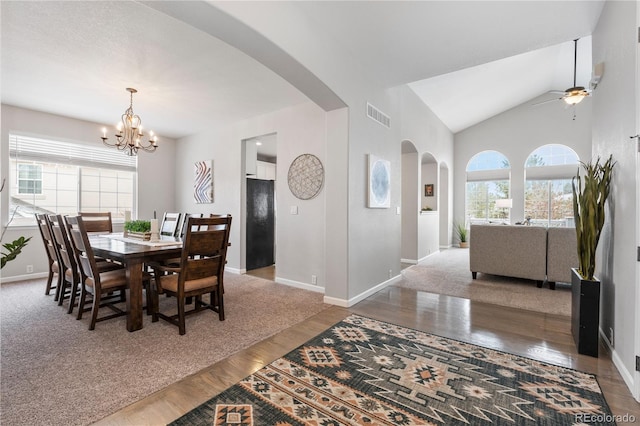 dining space with arched walkways, visible vents, a healthy amount of sunlight, and wood finished floors